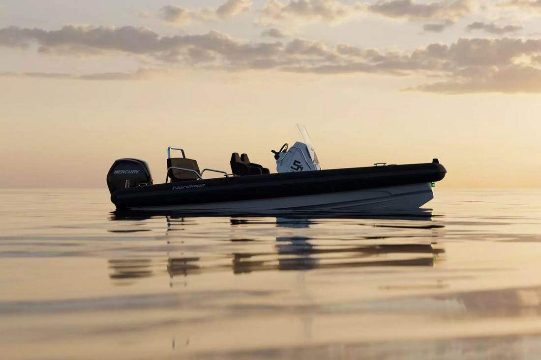 Sportsbåt på stille vann i solnedgang